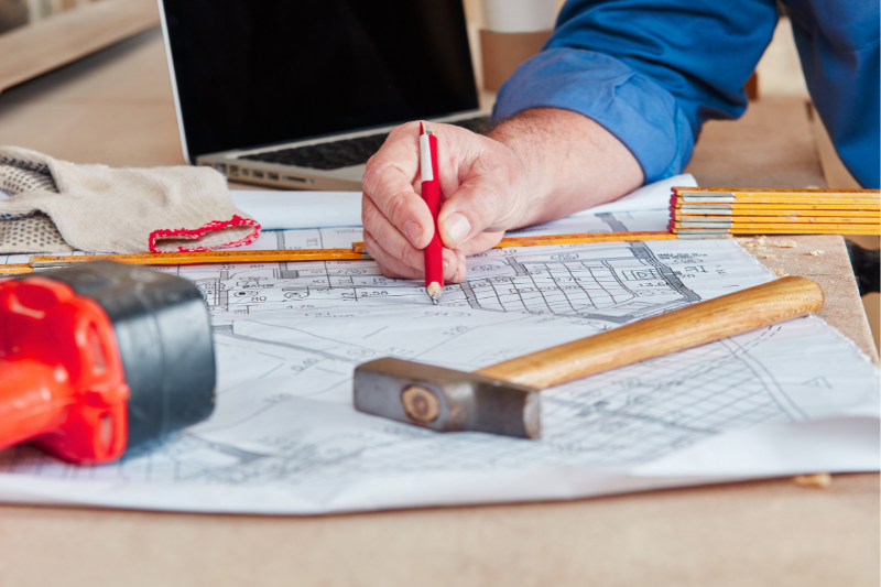 Construction plan and tools on workbench